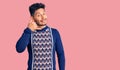 Handsome latin american young man wearing casual winter sweater smiling doing phone gesture with hand and fingers like talking on Royalty Free Stock Photo