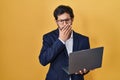 Handsome latin man working using computer laptop bored yawning tired covering mouth with hand Royalty Free Stock Photo