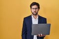 Handsome latin man working using computer laptop skeptic and nervous, frowning upset because of problem Royalty Free Stock Photo
