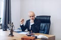 A handsome lawyer is sitting at a wooden table waiting for a contract to be signed by the customer. Royalty Free Stock Photo