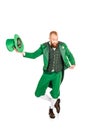 Handsome leprechaun in green costume holding hat