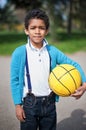 Handsome little black boy with a yellow ball in his hand in the park Royalty Free Stock Photo