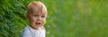 Handsome little boy, cheerful sitting on the lawn