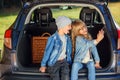 Front view of handsome 10-aged boy in hat and pretty 12-aged girl with blond long hair which taking photos on her phone Royalty Free Stock Photo