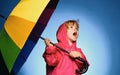 Handsome little guy in preparing for Autumn. Cheerful boy in raincoat with colorful umbrella. Kid in rain. Cloud rain