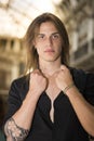 Handsome long hair young man indoors in elegant gallery