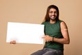 Handsome arab guy with plaster on shoulder showing blank placard