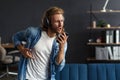 Handsome long haired curly man with headphones listening music,singing and dancing.Funny emotional smiling man with Royalty Free Stock Photo