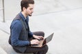 Handsome looking young Caucasian male typing on his fancy laptop