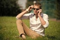 Handsome macho enjoy summer day. Businessman in sunglasses on sunny outdoor. Man relax on green grass. Fashion style and Royalty Free Stock Photo