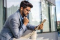 Handsome macho man sitting on stairs in front of modern office building Royalty Free Stock Photo