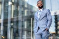 Handsome male african american business man CEO in a stylish chic suit at the workplace, standing confidently in front of financia Royalty Free Stock Photo