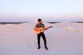 Handsome male Arab playing guitar standing in middle of bottomle