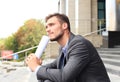 Handsome male business executive sitting on stairs outside a building. Royalty Free Stock Photo