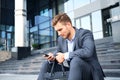 Handsome male business executive sitting on stairs outside a building. Royalty Free Stock Photo