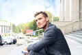 Handsome male business executive sitting on stairs outside a building. Royalty Free Stock Photo