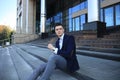 Handsome male business executive sitting on stairs outside a building. Royalty Free Stock Photo