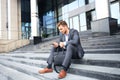 Handsome male business executive sitting on stairs outside a building. Royalty Free Stock Photo