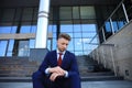 Handsome male business executive sitting on stairs outside a building. Royalty Free Stock Photo