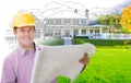 Handsome Male Contractor Wearing Hard Hat In Front of House Drawing Grada