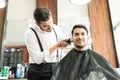 Customer Smiling While Barber Trimming His Hair In Shop