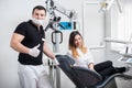 Handsome male dentist with attractive female patient in modern dental office Royalty Free Stock Photo