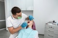 handsome male dentist conducts treatment for a young female patient.