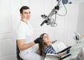 Handsome male dentist with happy female patient in modern dental clinic. Dentistry. Stomatology equipment