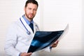 Handsome male doctor portrait holding patients x-ray