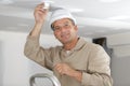 Handsome male electrician changing light bulb Royalty Free Stock Photo