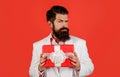 Handsome male with gift box. Serious bearded man in suit with present box. Attractive guy with present gift Royalty Free Stock Photo