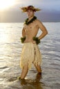 Handsome male hula dancer stands in the water as the sun sets. Royalty Free Stock Photo