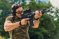 Handsome male instructor at shooting range. Medium outdoor shot of a muscular caucasian focused man in protective