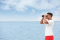 Handsome male lifeguard with binocular near sea Royalty Free Stock Photo