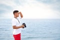 Handsome male lifeguard with binocular near sea Royalty Free Stock Photo