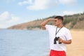 Handsome male lifeguard with binocular near sea Royalty Free Stock Photo