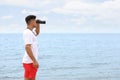 Handsome male lifeguard with binocular near sea Royalty Free Stock Photo