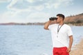 Handsome male lifeguard with binocular near sea Royalty Free Stock Photo