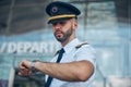 Handsome male pilot looking at wristwatch on the street Royalty Free Stock Photo