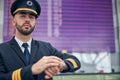 Handsome male pilot standing in airport terminal Royalty Free Stock Photo