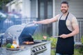 Handsome male preparing barbecue, grill outdoors. Man cooking meat and fish on barbecue in the backyard. Grill cook Royalty Free Stock Photo