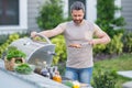 Handsome male preparing barbecue, grill outdoors. Man cooking meat and fish on barbecue in the backyard. Grill cook Royalty Free Stock Photo