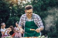 Male preparing barbecue outdoors for friends Royalty Free Stock Photo