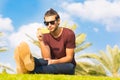 Handsome male sitting in the park using a cellphone