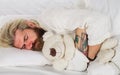 Handsome male sleeping with plush teddy bear relaxing in bed. Good night. Sleepy man in pajamas sleeping in bed at home Royalty Free Stock Photo