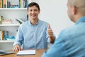 Handsome male IT specialist at job interview with businessman