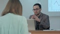 Handsome male teacher explain the class to group of hispanic students in class at school during lesson