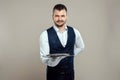 Handsome male waiter, white shirt, holds a silver tray, hand behind his back. Concept of wait staff serving customers in a Royalty Free Stock Photo