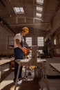 Handsome male worker using woodworking machine in workshop Royalty Free Stock Photo