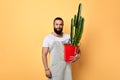 Handsome maler florist dressed in apron with a flower looking at the camera